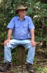 A very blurry photo of Bill Stanfield sitting on a stump