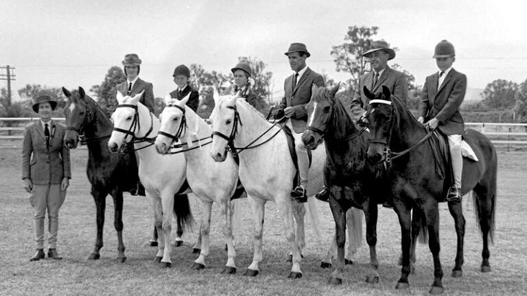 An old photo of people wearing dressage gear lined up on their horses
