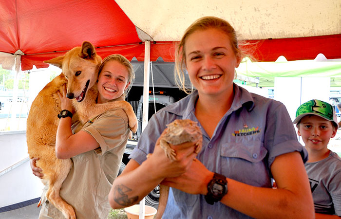 The Wildlife twins holding a dingo and a lizard